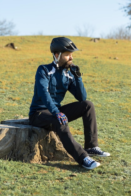 에어 서스펜션 포크가 있는 현대적인 탄소 하드테일 자전거에 바지와 양털 재킷을 입은 사이클리스트