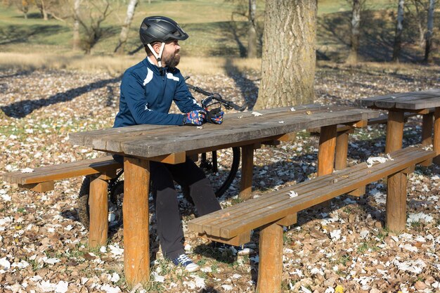 Cyclist in pants and fleece jacket on a modern hardtail bike with an suspension fork rides offroad