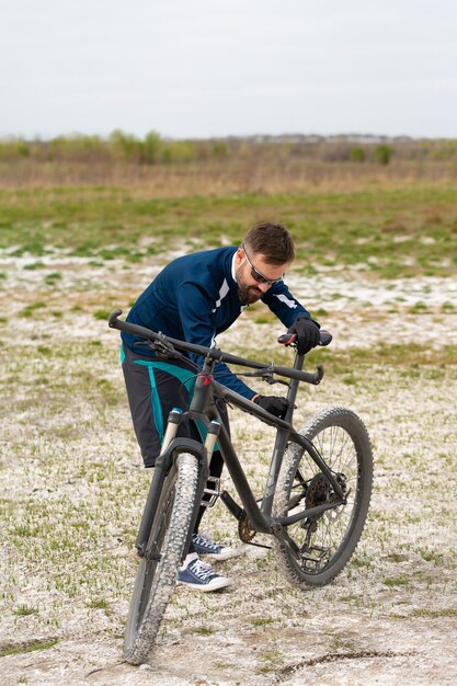 Cyclist repairs his bike in nature