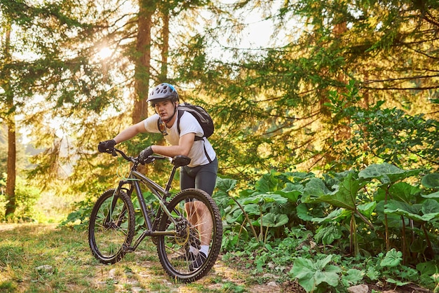 Cyclist resting after strenuous bike ride on forest roads