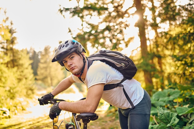 Cyclist resting after strenuous bike ride on forest roads