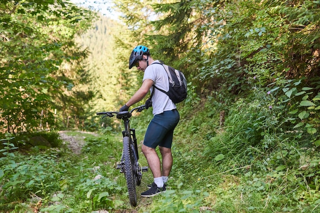 Велосипедист едет на велосипеде по экстремальным и опасным лесным дорогам Избирательный фокус