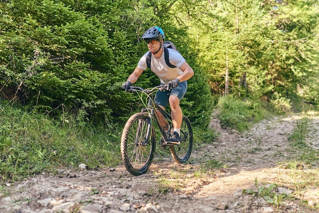 A cyclist rides a bike on extreme and dangerous forest roads\
selective focus