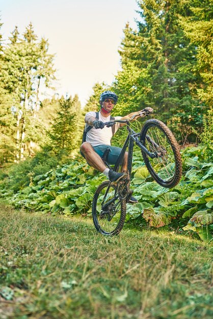 森の中のトレイルで自転車に乗るサイクリスト。エンデューロ トレイル トラックでサイクリングの男。スポーツ フィットネスの動機とインスピレーション。極端なスポーツ コンセプト。セレクティブ フォーカス。高品質の写真