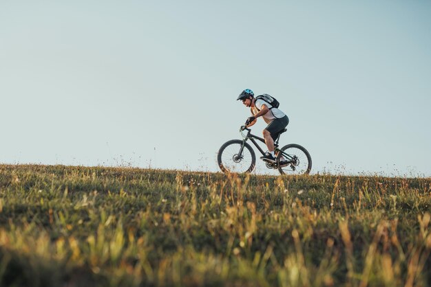 森のトレイルで自転車に乗るサイクリストエンデューロトレイルトラックでサイクリングする男性スポーツフィットネスの動機とインスピレーションエクストリームスポーツコンセプトセレクティブフォーカス高品質の写真