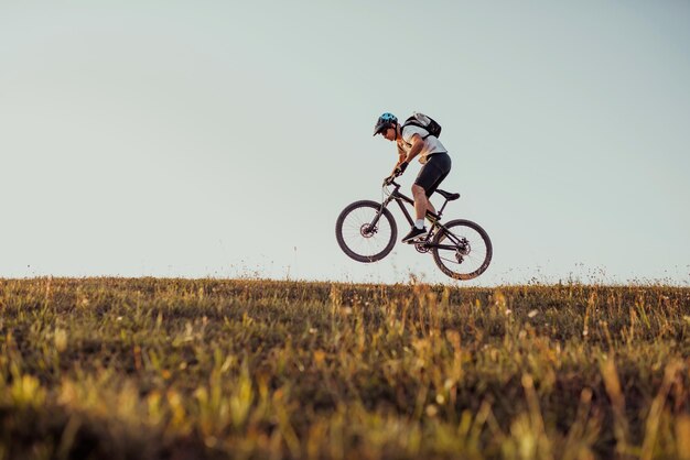 森のトレイルで自転車に乗るサイクリストエンデューロトレイルトラックでサイクリングする男性スポーツフィットネスの動機とインスピレーションエクストリームスポーツコンセプトセレクティブフォーカス高品質の写真