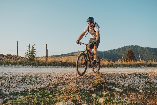 森のトレイルで自転車に乗るサイクリストエンデューロトレイルトラックでサイクリングする男性スポーツフィットネスの動機とインスピレーションエクストリームスポーツコンセプトセレクティブフォーカス高品質の写真