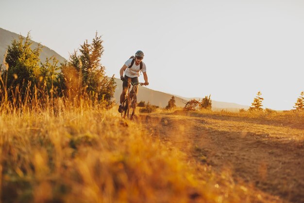 森のトレイルで自転車に乗るサイクリストエンデューロトレイルトラックでサイクリングする男性スポーツフィットネスの動機とインスピレーションエクストリームスポーツコンセプトセレクティブフォーカス高品質の写真