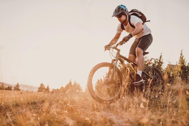 森のトレイルで自転車に乗るサイクリストエンデューロトレイルトラックでサイクリングする男性スポーツフィットネスの動機とインスピレーションエクストリームスポーツコンセプトセレクティブフォーカス高品質の写真