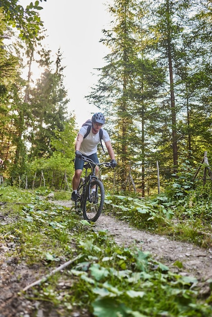 Cyclist Riding the Bike on the Trail in the Forest Man cycling on enduro trail track Sport fitness motivation and inspiration Extreme Sport Concept Selective focus