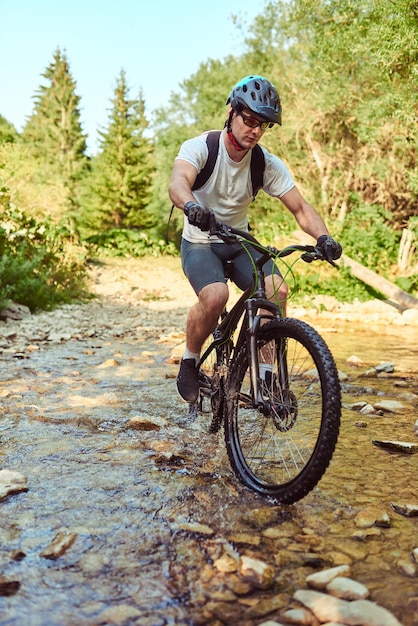 Cyclist riding the bike on the trail in the forest man cycling\
on enduro trail track sport fitness motivation and inspiration\
extreme sport concept selective focus