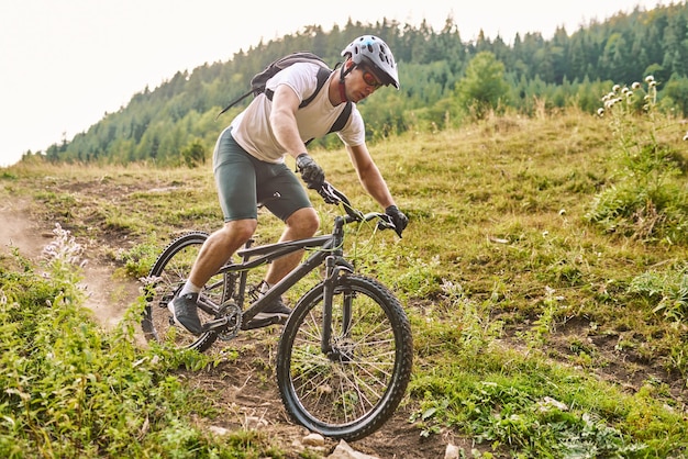 森のトレイルで自転車に乗るサイクリストエンデューロトレイルトラックでサイクリングする男性スポーツフィットネスの動機とインスピレーションエクストリームスポーツコンセプトセレクティブフォーカス