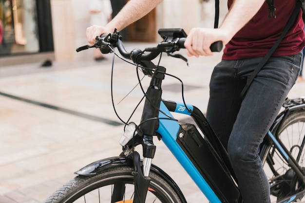 Ciclista che guida l'e-bike attraverso la città