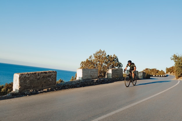 Cyclist riding on his bicycle at coastal road in the morning