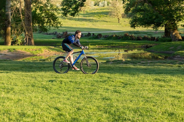 Cyclist in shorts and jersey on a modern carbon hardtail bike with an air suspension fork