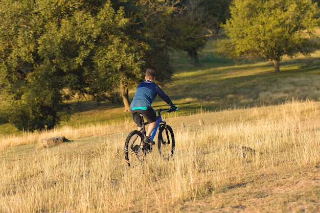 Cyclist in shorts and jersey on a modern carbon hardtail bike with an air suspension fork