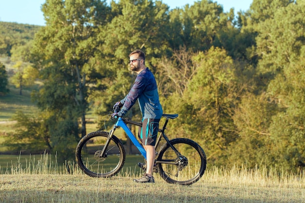 Cyclist in shorts and jersey on a modern carbon hardtail bike with an air suspension fork