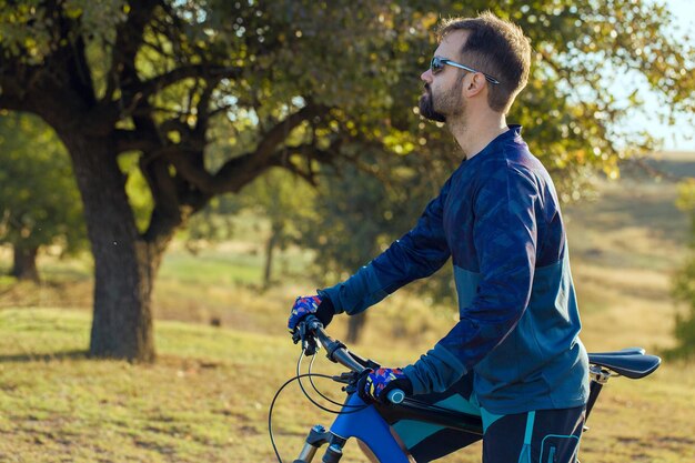 에어 서스펜션 포크가 있는 현대적인 탄소 하드테일 자전거를 타는 반바지와 저지를 입은 사이클리스트