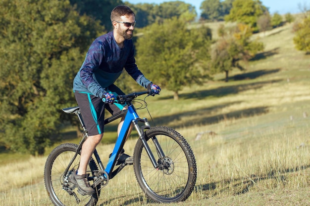 Cyclist in shorts and jersey on a modern carbon hardtail bike with an air suspension fork