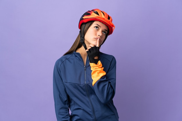 Cyclist woman having doubts while looking up