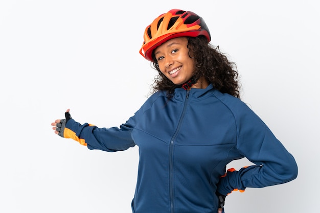 Cyclist woman isolated on white extending hands to the side for inviting to come