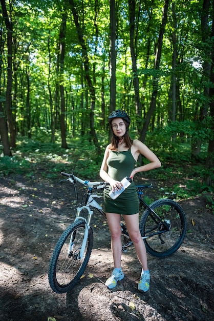 La donna ciclista trascorre il tempo libero nella foresta durante l'avventura estiva