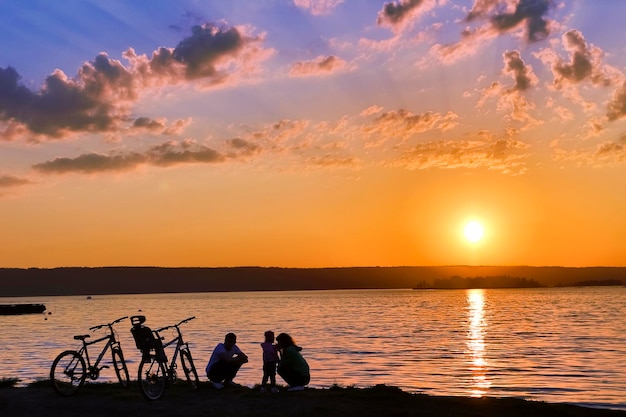 Cyclists at the river at sunset