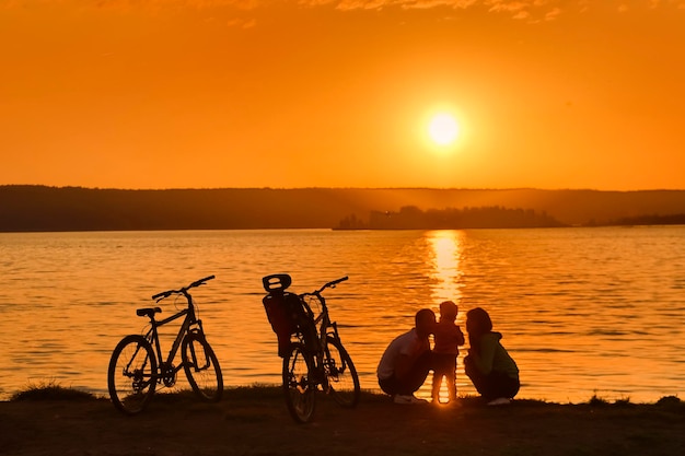 Cyclists at the river at sunset