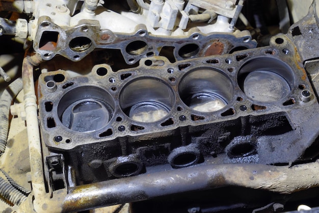 The cylinder block of the fourcylinder engine Disassembled motor vehicle for repair Parts in engine oil Car engine repair in the service