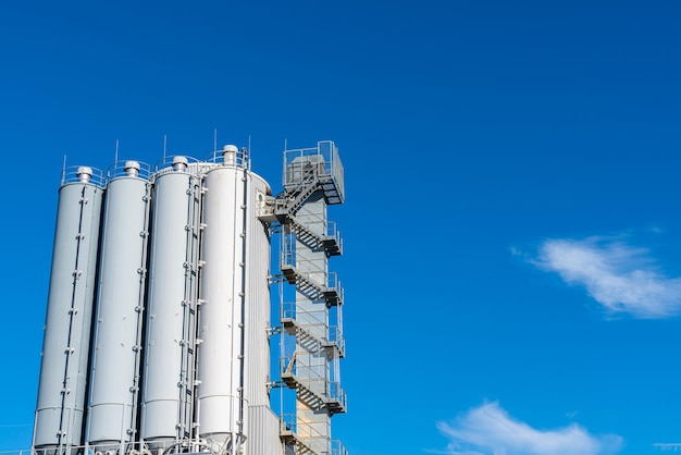 Cylindrical tower of an industrial building against the blue sky