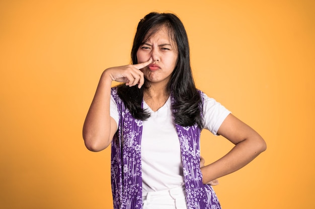 Cynische uitdrukking van een Aziatische vrouw terwijl ze over een geïsoleerde achtergrond staat