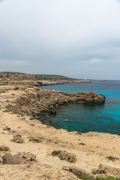 CYPRUS KAAP CAVO GRECO Toeristen zeilden op een motorboot de blauwe lagune in