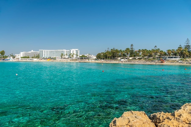 CYPRUS NISSI BEACH 관광객들은 섬에서 가장 인기 있는 해변 중 한 곳에서 휴식을 취하고 수영을 즐깁니다.