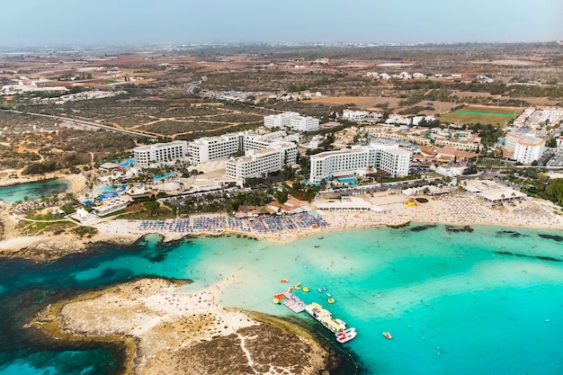 Cyprus prachtige kustlijn, Middellandse Zee van turquoise kleur. Huizen aan de Middellandse Zeekust. Toeristisch stadje. Nissi-strand. Zomervakantie op zee. bovenaanzicht, luchtfoto. Cyprus, Agia NAPA.