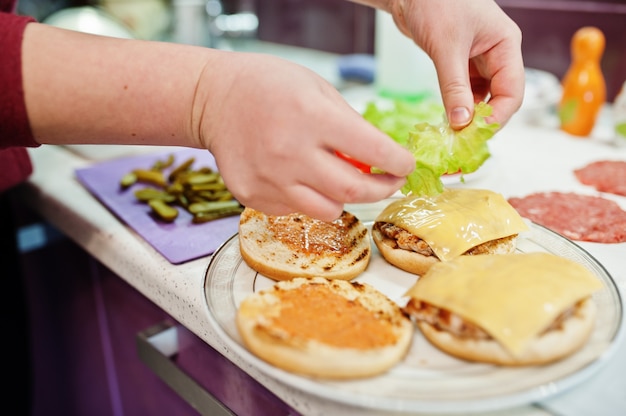 検疫時間中に自宅のキッチンでハンバーガーを調理する。