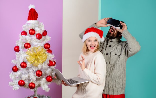 Foto d technologie virtual reality entertainment vrouw in kerstmuts met laptop bebaarde man in virtuele d