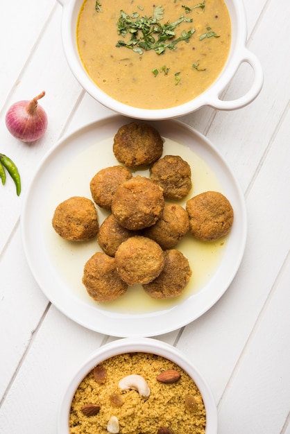 Daal baati churma is een populaire gezonde voeding uit rajasthan, india. geserveerd in wit servies op een humeurige achtergrond.