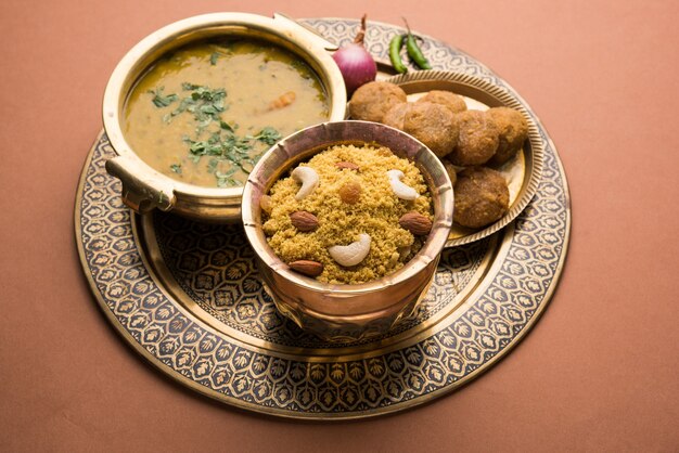 Daal Baati Churma is een populaire gezonde voeding uit Rajasthan, India. Geserveerd in wit servies op een humeurige achtergrond.