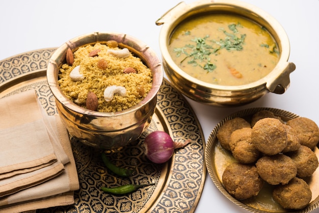 Daal Baati Churma is a popular Healthy food from Rajasthan, India. Served in white crockery over moody background.