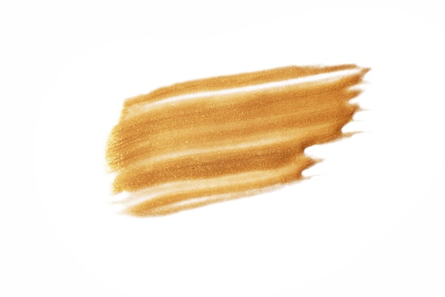 A dab of gold paint on a white background