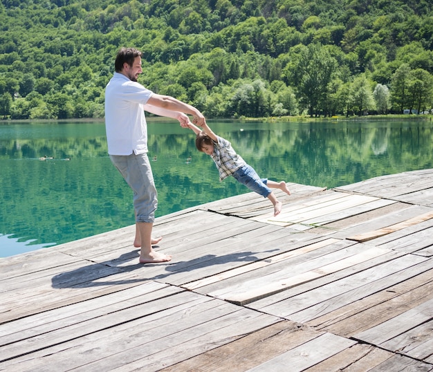 山の湖で遊んでいるお父さんと息子