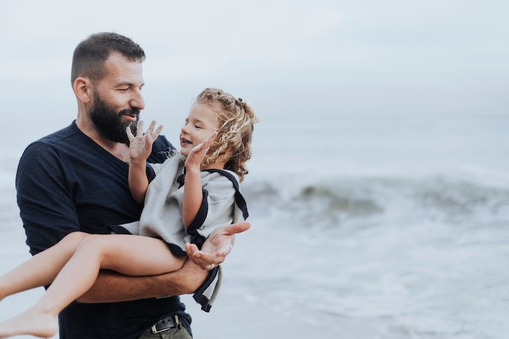 Photo dad carrying her playful daughter