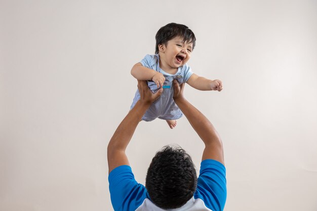 父の日に腕を伸ばして息子を空中で運ぶお父さん