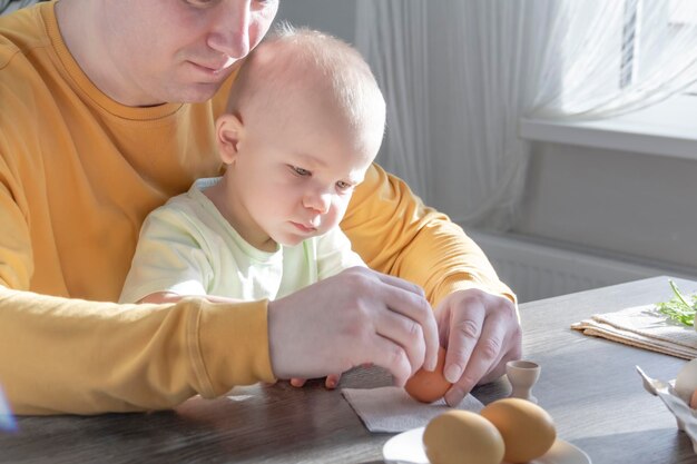 A dad celebrates Easter with his young son They beat eggs eat eggs and have breakfast Dad teaches the child