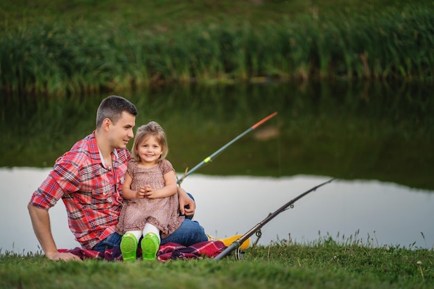 Dad and child fishing at lake