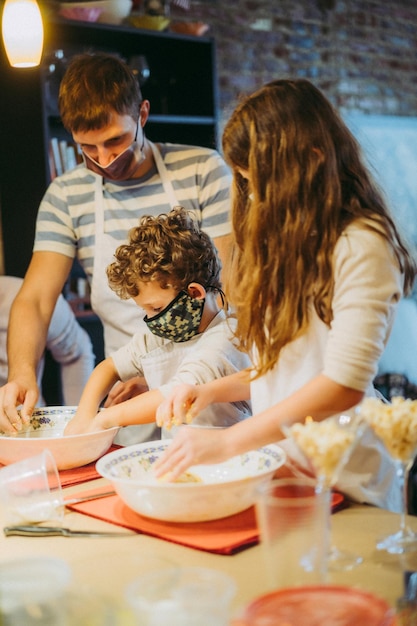 Папа и дети готовят пасту на мастер-классе по гастрономии