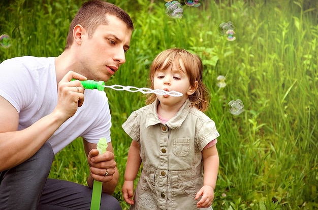 Dad and daughter blowing soap bubbles Father's Day family day