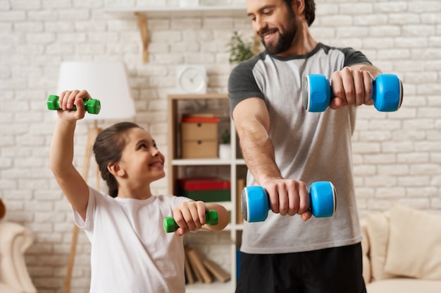 Dad and Daughter Doing Exercises With Dumbbells