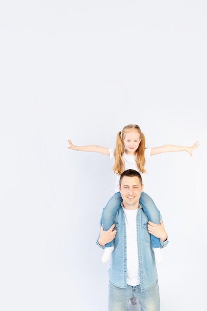 Dad and daughter on their shoulders smiling and having fun on a white isolated background empty space for text happy family or fatherhood