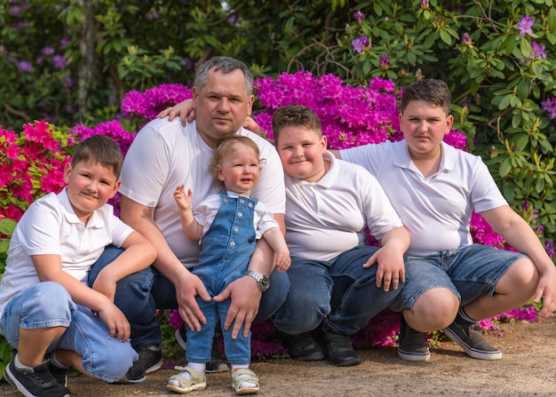 dad and four sons of different ages the youngest is one year old Joyfully hug each other